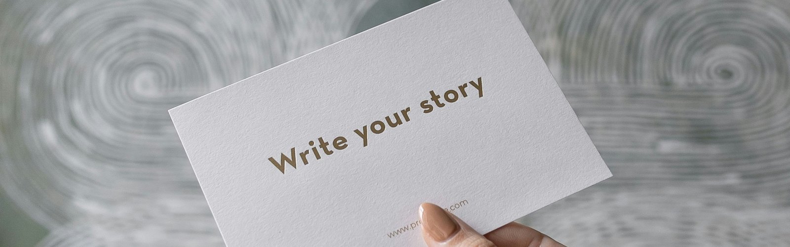 A hand holding a card that reads Write your story