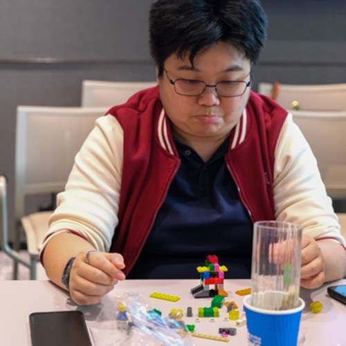 Participant focused on building his LEGO model during a workshop