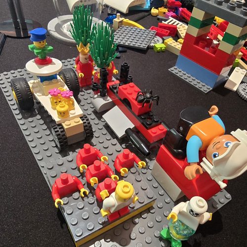 Group workshop in progress, seated around a table with LEGO bricks