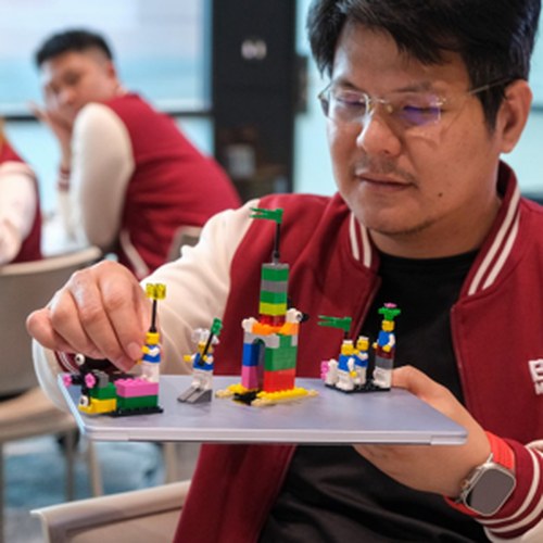 Participant presenting his finished LEGO model to the group